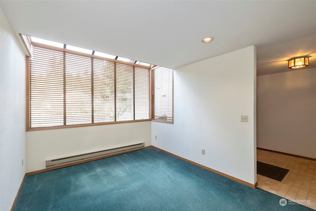 unfurnished room featuring a baseboard heating unit and carpet flooring