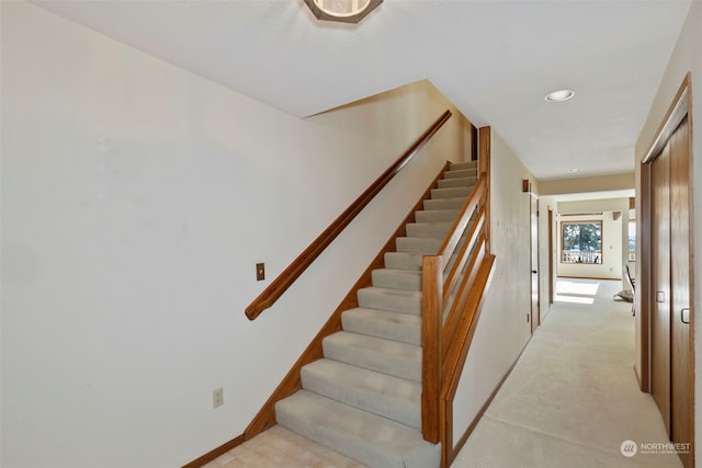 stairs featuring carpet flooring