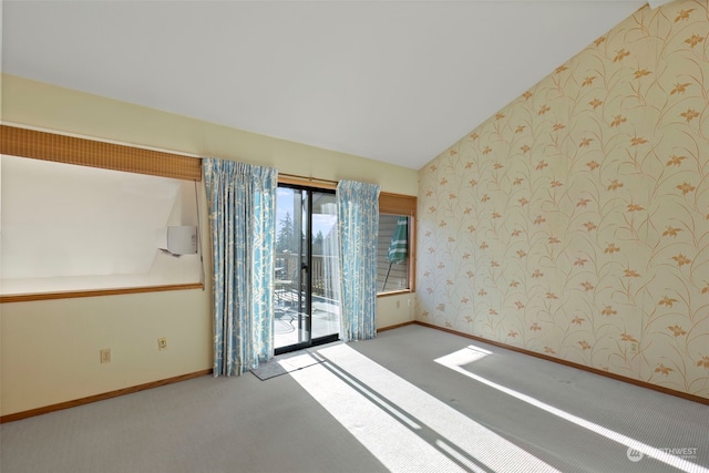 carpeted empty room featuring lofted ceiling