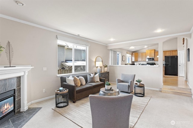 carpeted living room featuring lofted ceiling, ornamental molding, and a fireplace