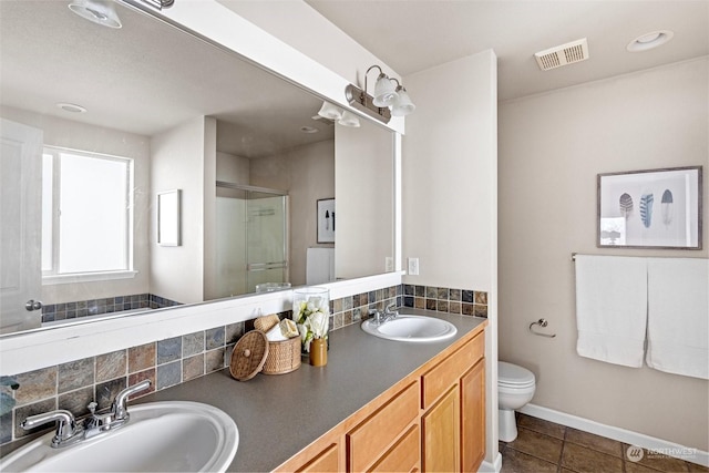 bathroom featuring walk in shower, vanity, toilet, and tile patterned flooring