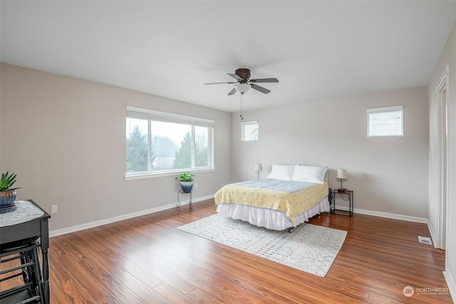 bedroom with dark hardwood / wood-style floors and ceiling fan