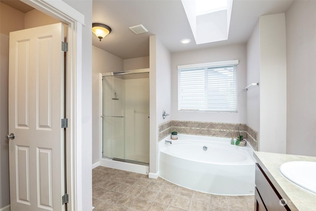 bathroom with vanity, a skylight, and plus walk in shower