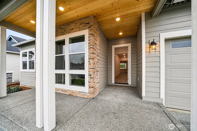 entrance to property with stone siding and an attached garage