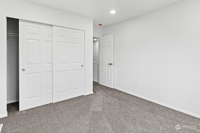 unfurnished bedroom featuring a closet and dark colored carpet