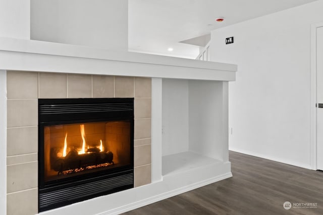 room details featuring wood-type flooring and a tile fireplace