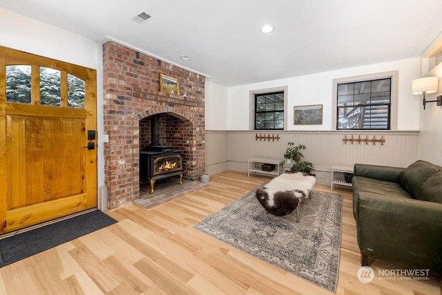 living room with wood-type flooring and a wood stove