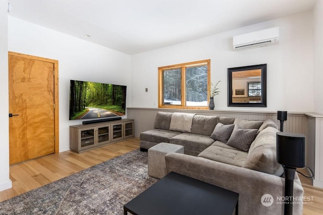 living room featuring wood-type flooring and an AC wall unit