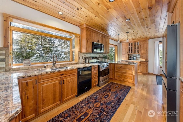 kitchen featuring pendant lighting, tasteful backsplash, sink, light stone counters, and stainless steel appliances