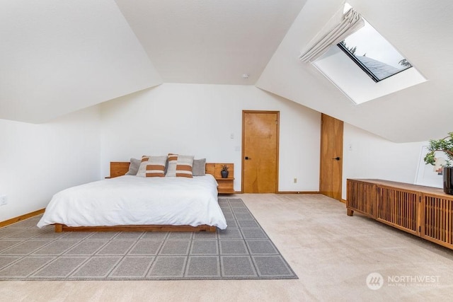 bedroom with lofted ceiling with skylight and carpet floors