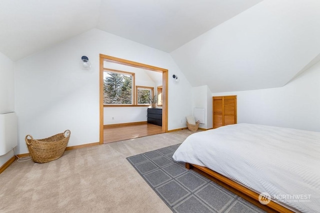 carpeted bedroom with lofted ceiling