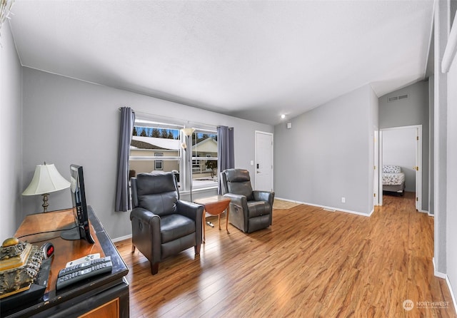 sitting room with vaulted ceiling and light hardwood / wood-style flooring