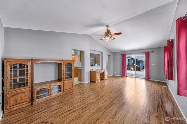 unfurnished living room featuring lofted ceiling, hardwood / wood-style flooring, and ceiling fan