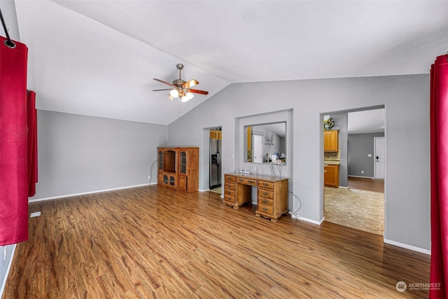 unfurnished living room with wood-type flooring, ceiling fan, and vaulted ceiling