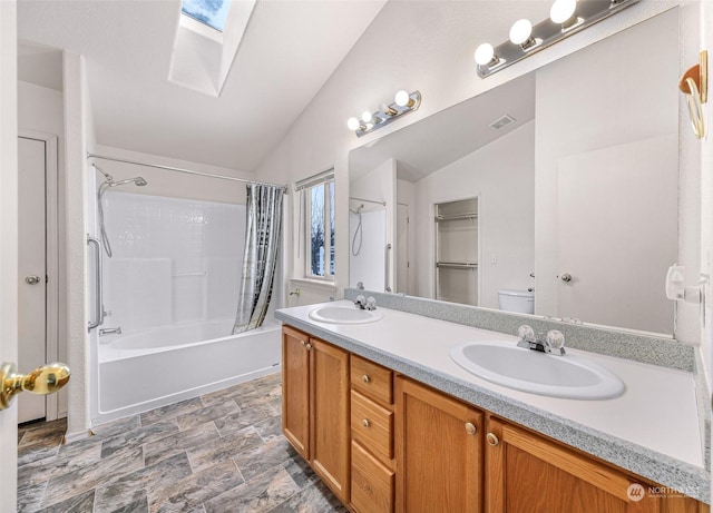 full bathroom with shower / tub combo with curtain, vanity, toilet, and vaulted ceiling with skylight