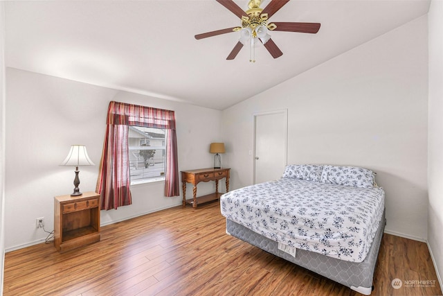 bedroom with hardwood / wood-style flooring, ceiling fan, and vaulted ceiling