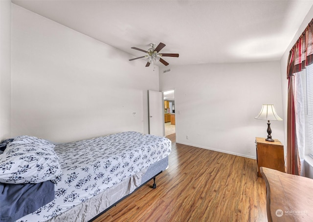 bedroom with lofted ceiling, hardwood / wood-style floors, and ceiling fan