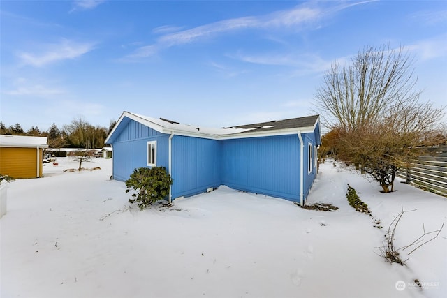 view of snow covered back of property