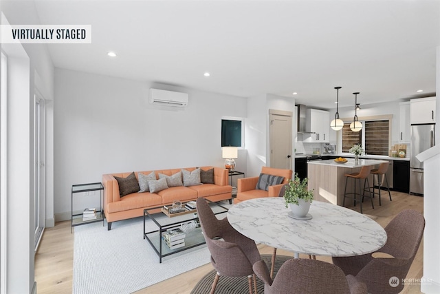 dining space with a wall mounted AC and light wood-type flooring