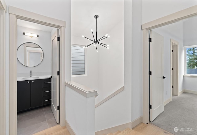 corridor with sink and a notable chandelier