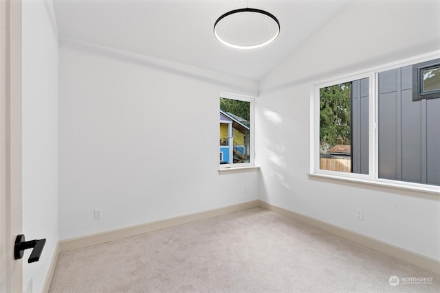 unfurnished room with light carpet and vaulted ceiling