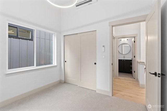 unfurnished bedroom with a closet, sink, and light carpet