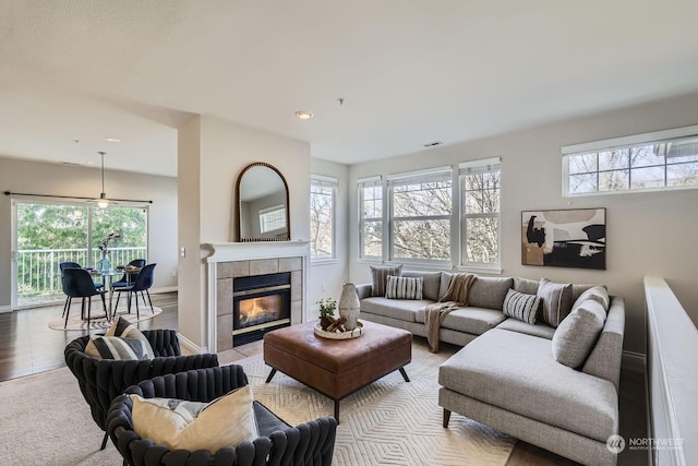 living room with light wood-type flooring, a wealth of natural light, and a fireplace