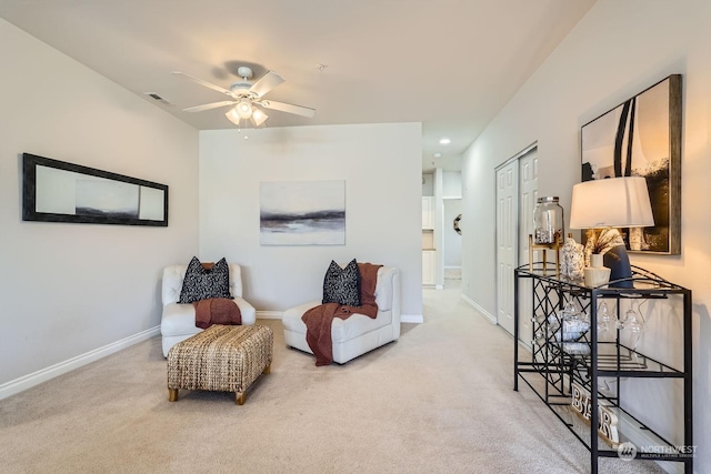 living area with ceiling fan and light carpet