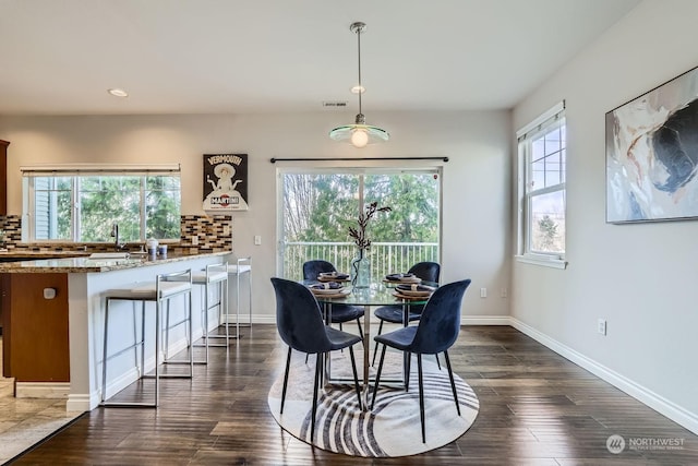 dining room with dark hardwood / wood-style floors and sink