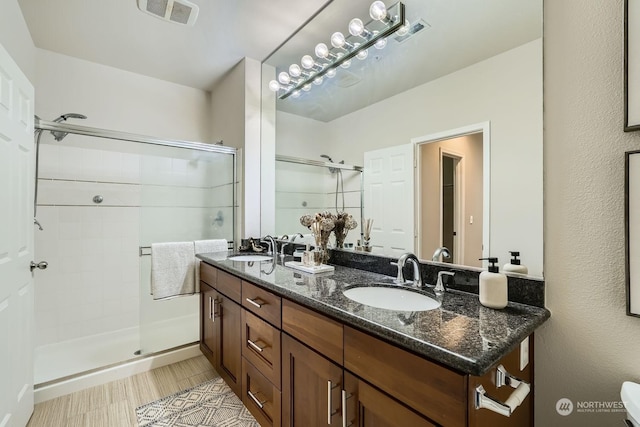 bathroom featuring an enclosed shower and vanity