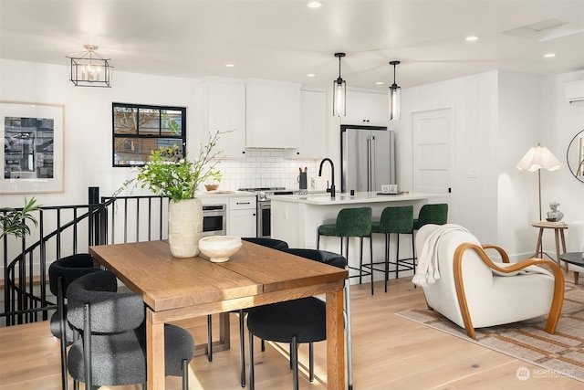 dining room featuring sink and light hardwood / wood-style flooring