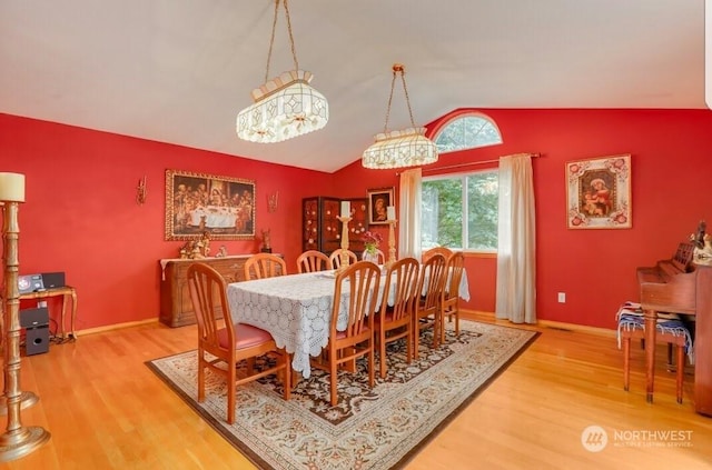 dining room with lofted ceiling and wood-type flooring