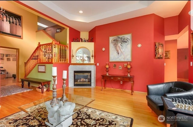 living room featuring a tray ceiling and wood-type flooring