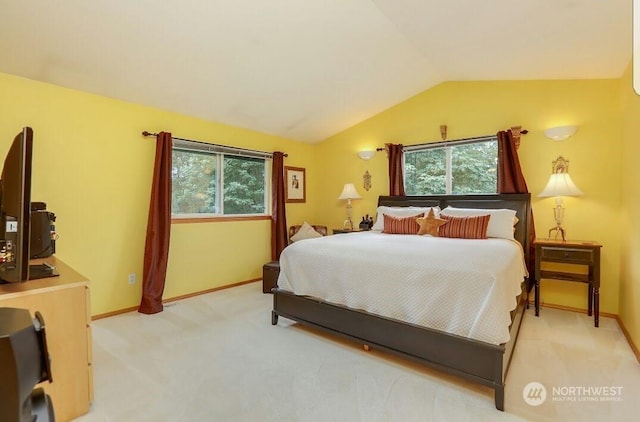 bedroom with multiple windows, vaulted ceiling, and light carpet