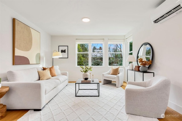 living room featuring a wall mounted air conditioner and light hardwood / wood-style flooring