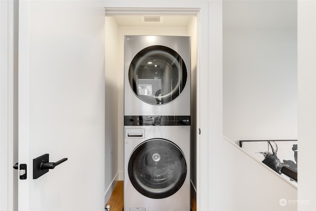 washroom with stacked washer / dryer and hardwood / wood-style floors