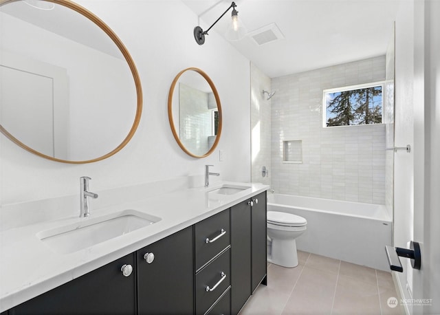 full bathroom with vanity, tiled shower / bath combo, tile patterned floors, and toilet