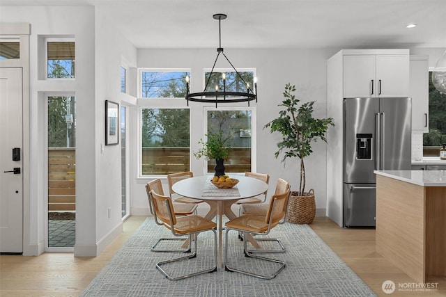 dining room featuring recessed lighting, a notable chandelier, light wood-style flooring, and baseboards