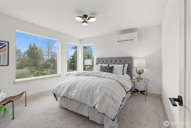 bedroom with a wall mounted air conditioner, carpet flooring, and baseboards