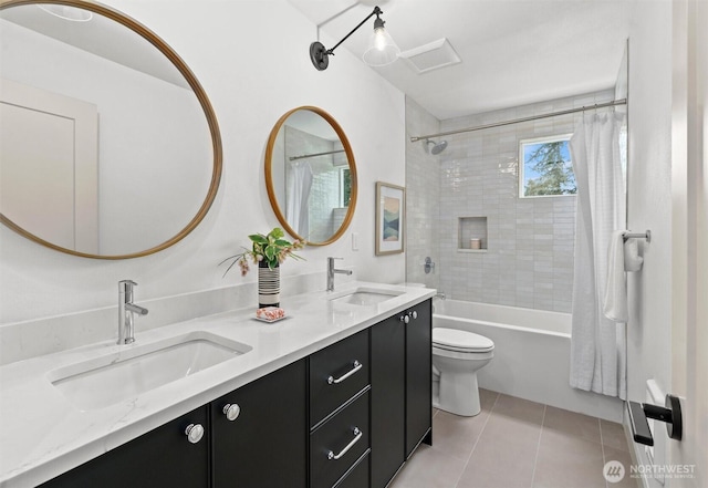 bathroom with double vanity, a sink, toilet, and tile patterned floors