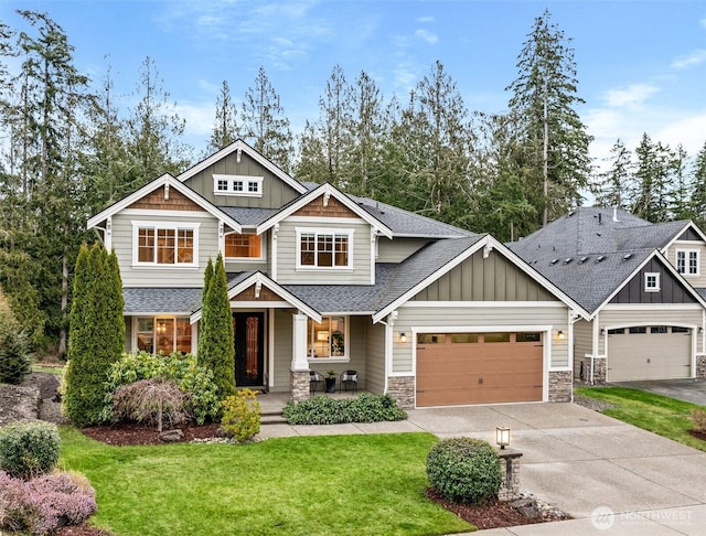 craftsman-style home featuring driveway, a shingled roof, board and batten siding, and a front yard