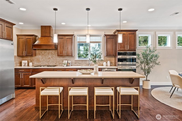 kitchen featuring visible vents, custom exhaust hood, stainless steel appliances, and light countertops