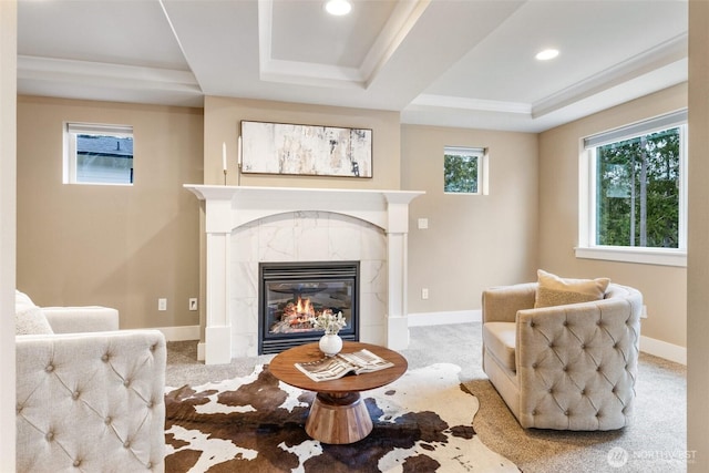 sitting room with a tiled fireplace, carpet flooring, and baseboards