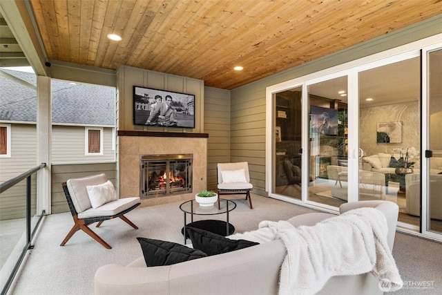 interior space with wooden ceiling, wooden walls, recessed lighting, a fireplace, and carpet