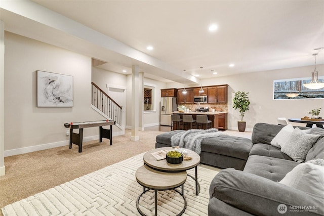 living room featuring stairs, light carpet, baseboards, and recessed lighting