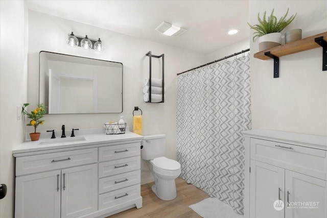 bathroom with vanity, hardwood / wood-style floors, and toilet