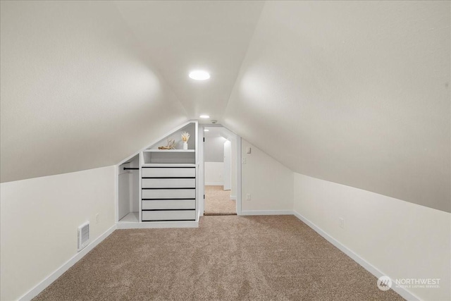 bonus room featuring vaulted ceiling and light carpet