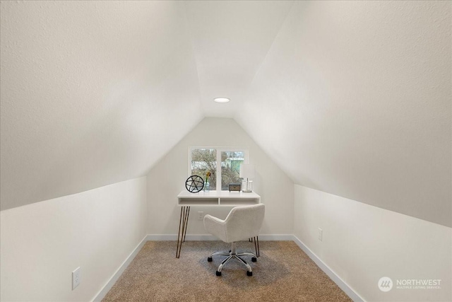 carpeted office space featuring vaulted ceiling