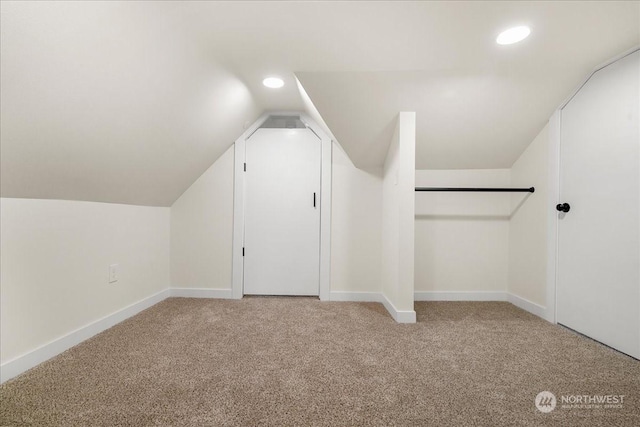 bonus room featuring vaulted ceiling and light carpet