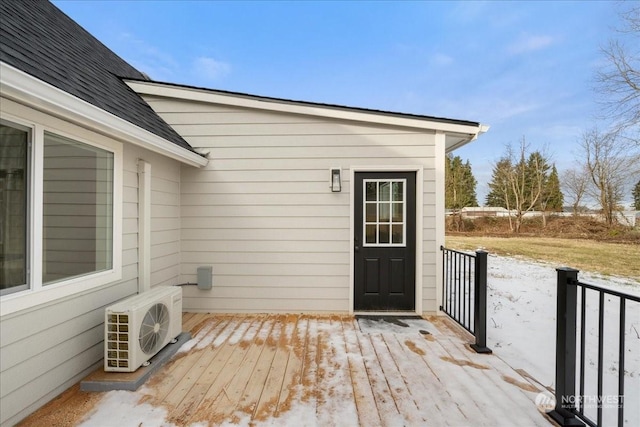 view of exterior entry featuring a wooden deck and ac unit